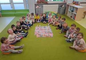 Dzieci pozują do pamiątkowego zdjęcia z upominkami z okazji Dnia Kobiet.
