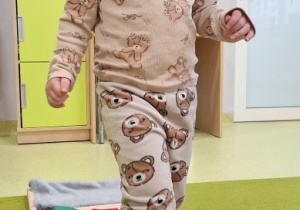 Jagna idzie boso przez ścieżkę sensoryczną.